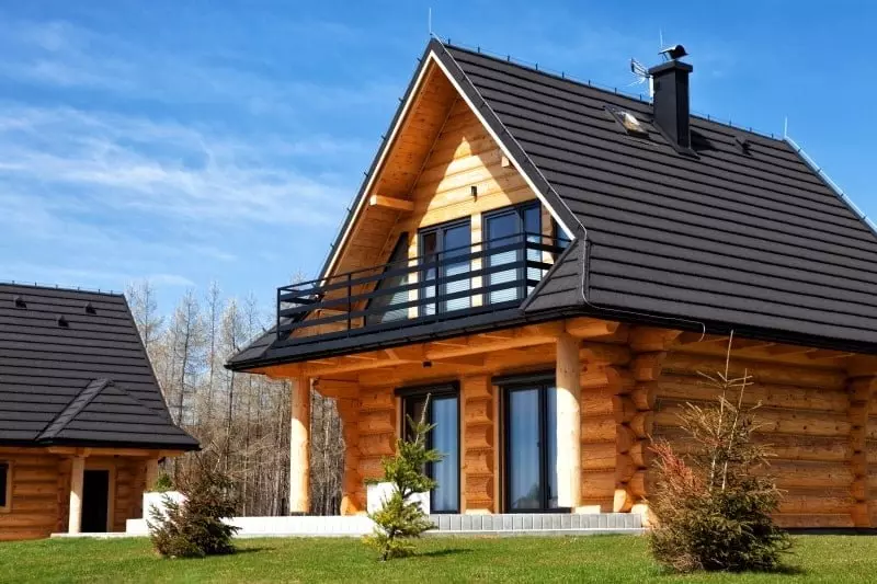Holzhaus mit Holzbalken und dunklen Dachziegeln