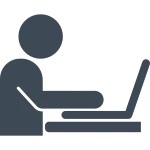 Eine Person sitzt vor einem Laptop