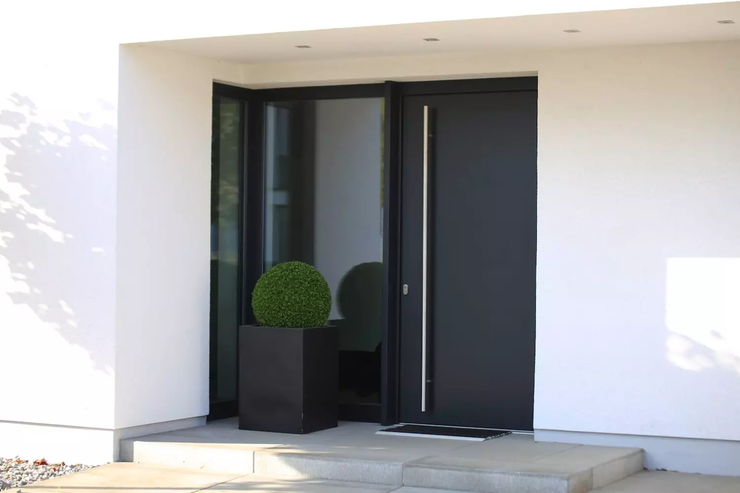 Eine dunkle Haustüre aus Aluminium mit breitem Seitenteil